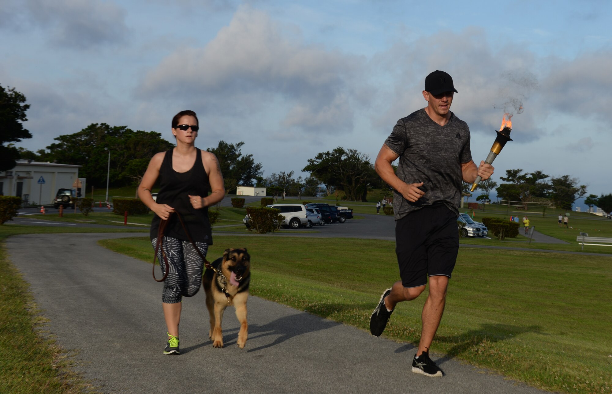 U.S. Air Force Tech. Sgt. David Aenchbacher, 18th Security Forces Squadron kennel master, and Staff Sgt. Daniel Farmer, 18th SFS military working dog handler, run with a torch for the National Police Week’s 24-hour vigil run on Kadena Air Base, Japan, May 19, 2015. During the run, law enforcement personnel kept the torch aloft and burning for more than 24 hours. (U.S. Air Force photo by Senior Airman Omari Bernard)