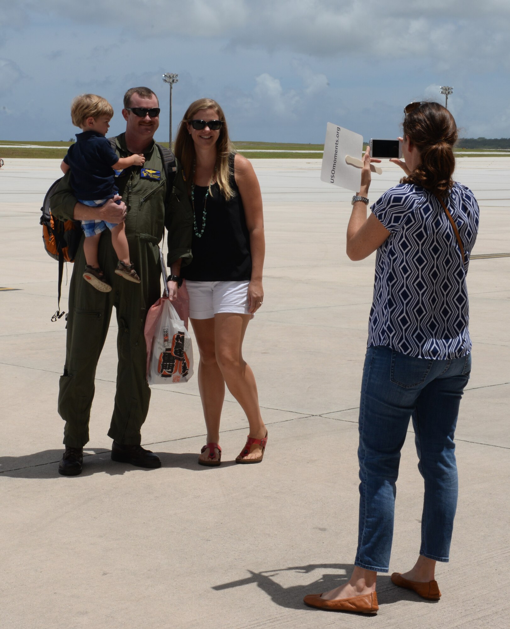 Lt. Cmdr. Brian Musfeldt, Helicopter Sea Combat Squadron 25 operations officer, smiles for a photo with his family after a five month deployment May 11, 2015, at Andersen Air Force Base, Guam. While deployed, the members of HSC-25 successfully integrated three MH-60S helicopters with the Air Combat Element during amphibious integration training and certification exercise and Korea Marine Exchange Program. (U.S. Air Force photo by Senior Airman Amanda Morris/Released)