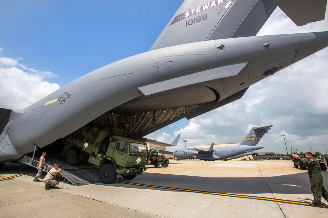 Air Force Master Sgt. Andy Grimes, right, directs a light medium tactical vehicle onto a C-17 Globemaster III aircraft during a deployment exercise on Joint Base McGuire-Dix-Lakehurst, N.J., May 11, 2015. Grimes is a loadmaster assigned to the New York Air National Guard's 105th Airlift Wing.