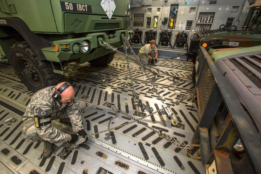 Air Force Tech. Sgt. Christopher Weiss, left, and Airman 1st Class Lacy Thompson tie down Humvees on a C-17 Globemaster III aircraft during a deployment exercise on Joint Base McGuire-Dix-Lakehurst, N.J., May 11, 2015. Weiss is assigned to the 35th Aerial Port Squadron and Thompson is assigned to the 305th Aerial Port Squadron.