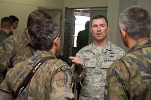 Tech Sgt. Daniel Foret, 571st Mobility Support Advisory Squadron survival, evasion, resistance and escape specialists, speaks with members of the Brazilian air force after a presentation on May 11, 2015 in Campo Grande, Brazil. Foret spoke and explained the importance of SERE specialists and how they can be utilized to train forces. (U.S. Air Force photo by Staff Sgt. Adam Grant/Released)
