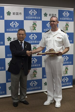 Navy Lt. Nathan Hemerly, a family medicine doctor at the Robert M. Casey Medical and Dental Clinic, and Akehiko Date, chairmen at the General Incorporated Association Iwakuni City Sports Association, pose for a picture after Date presented Hemerly with a certificate of appreciation at the City Hall in Iwakuni City, Japan, May 12, 2015. After participating in the 9th annual Kintaikyo Road Race in Iwakuni City, Hemerly performed CPR, with the help of a local Japanese nurse, on another run participant who fell and became unconscious during the race. “I was just doing what I thought was the right thing to do, I wasn’t looking for any attention,” said Hemerly.