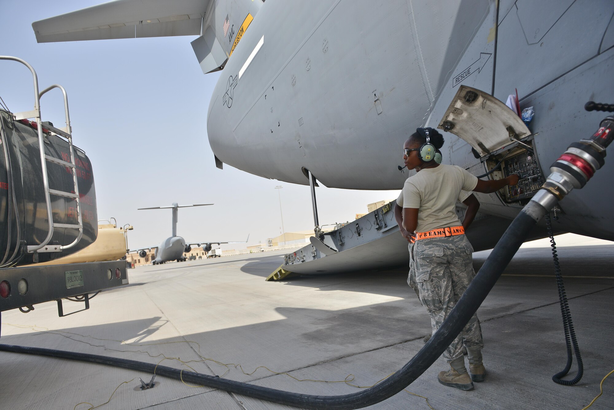 Airman 1st Class Diedre Brown, 8th Expeditionary Air Mobility Squadron, coordinates fuel shut-off for a C-17 Globemaster aircraft during pre-flight inspections May 13, 2015 at Al Udeid Air Base, Qatar. Airmen from separate squadrons deployed to Al Udeid helped support a mission for forward deployed members of RED HORSE Civil Engineering to repair a runway in Southwest Asia in support of Operation Inherent Resolve. (U.S. Air Force photo/Staff Sgt. Alexandre Montes)