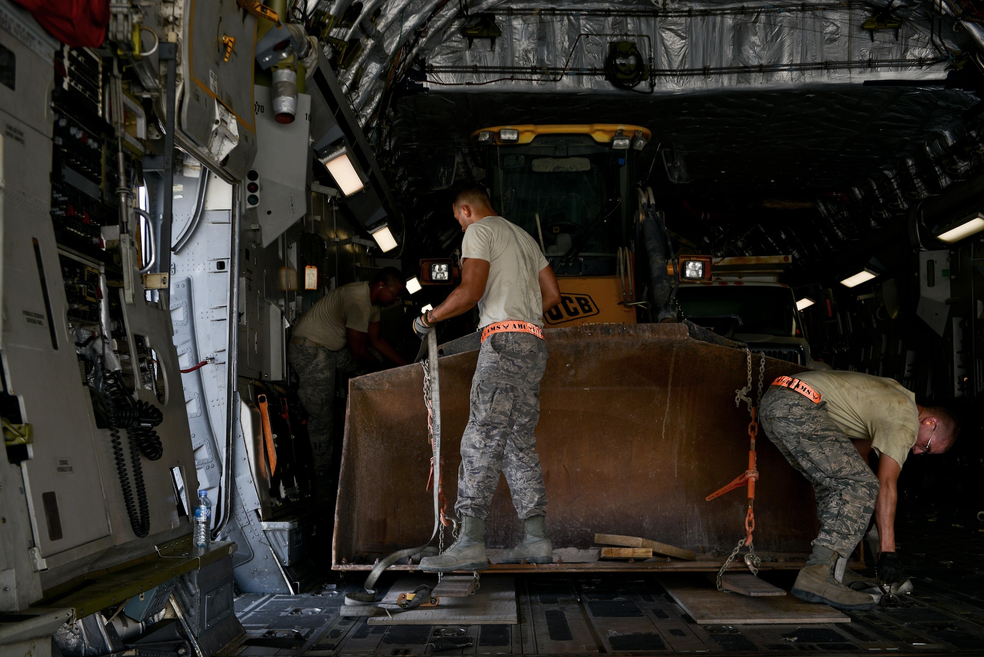 Airmen from the 8th Expeditionary Air Mobility Squadron make final checks while securing a bulldozer onto a -17 Globemaster aircraft prior to take off May 13, 2015 at Al Udeid Air Base, Qatar. Airmen from separate squadrons deployed to Al Udeid helped support a mission for forward deployed members of RED HORSE Civil Engineering to repair a runway in Southwest Asia in support of Operation Inherent Resolve. (U.S. Air Force photo/Staff Sgt. Alexandre Montes)