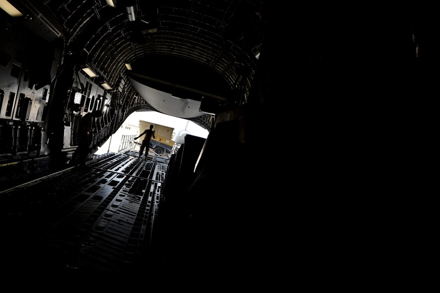 Airmen from the 8th Expeditionary Air Mobility Squadron load generators onto a C-17 Globemaster aircraft prior to take off May 13, 2015 at Al Udeid Air Base, Qatar. Airmen from separate squadrons deployed to Al Udeid helped support a mission for forward deployed members of RED HORSE Civil Engineering to repair a runway in Southwest Asia in support of Operation Inherent Resolve. (U.S. Air Force photo/Staff Sgt. Alexandre Montes)