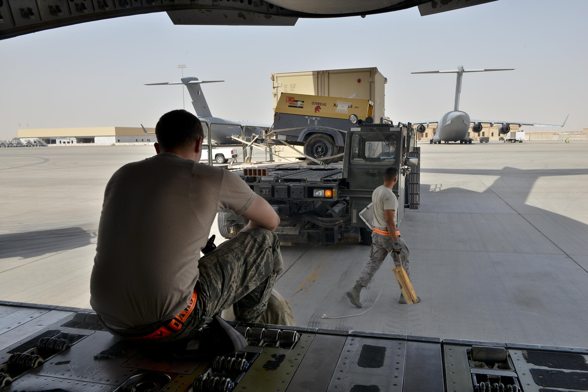 Airmen from the 8th Expeditionary Air Mobility Squadron realign a 25K loader up to a C-17 Globemaster aircraft prior to take off May 13, 2015 at Al Udeid Air Base, Qatar. Airmen from separate squadrons deployed to Al Udeid helped support a mission for forward deployed members of RED HORSE Civil Engineering to repair a runway in Southwest Asia in support of Operation Inherent Resolve. (U.S. Air Force photo/Staff Sgt. Alexandre Montes)