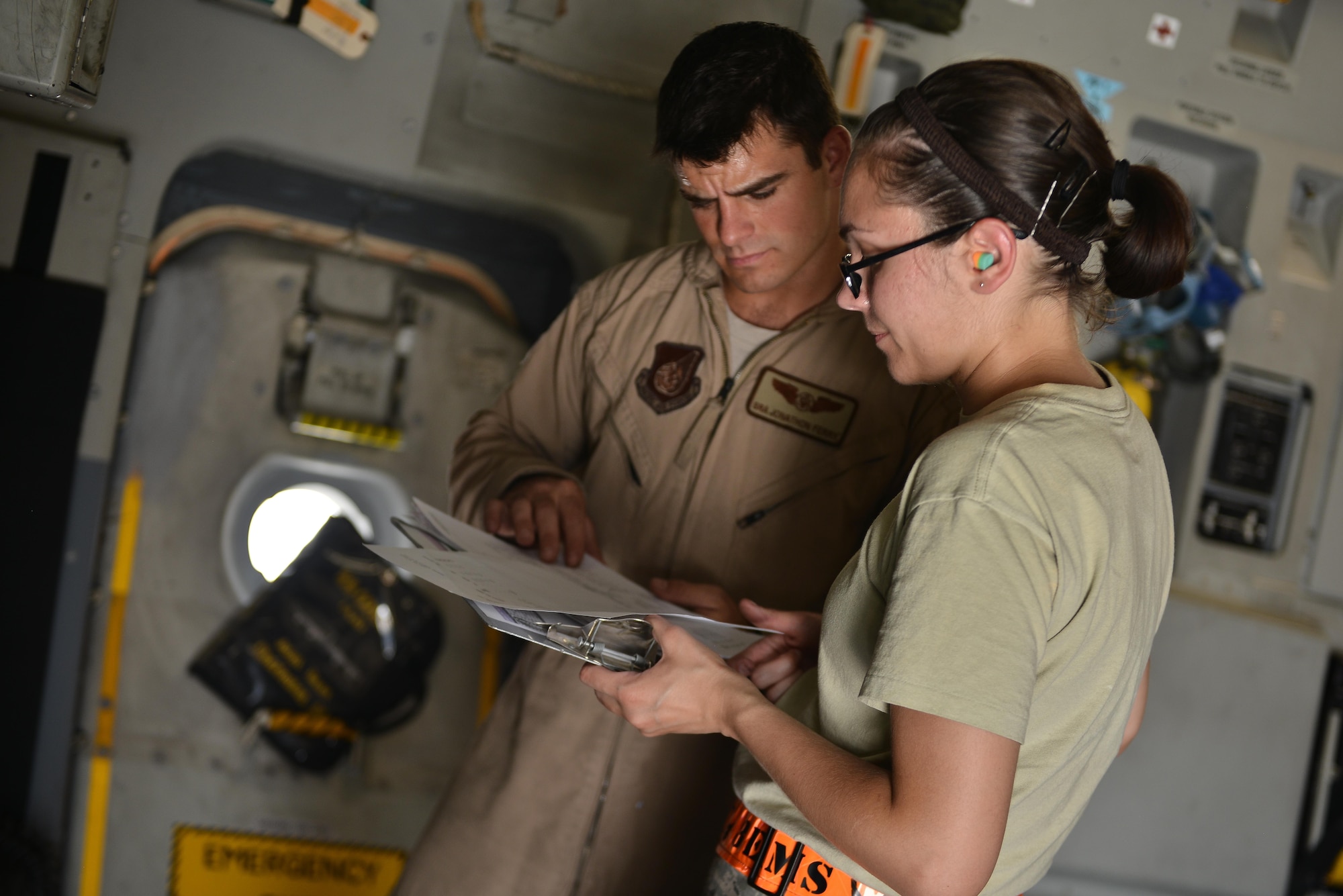 Senior Airman Jonathon Ferry, 816th Expeditionary Airlift Squadron and Airman 1st Class Kimberly Wolfgang, 8th Expeditionary Air Mobility Squadron, review an equipment manifest to configure weight distribution on a C-17 Globemaster aircraft May 13, 2015 at Al Udeid Air Base, Qatar. Airmen from separate squadrons deployed to Al Udeid helped support a mission for forward deployed members of RED HORSE Civil Engineering to repair a runway in Southwest Asia in support of Operation Inherent Resolve. (U.S. Air Force photo/Staff Sgt. Alexandre Montes)