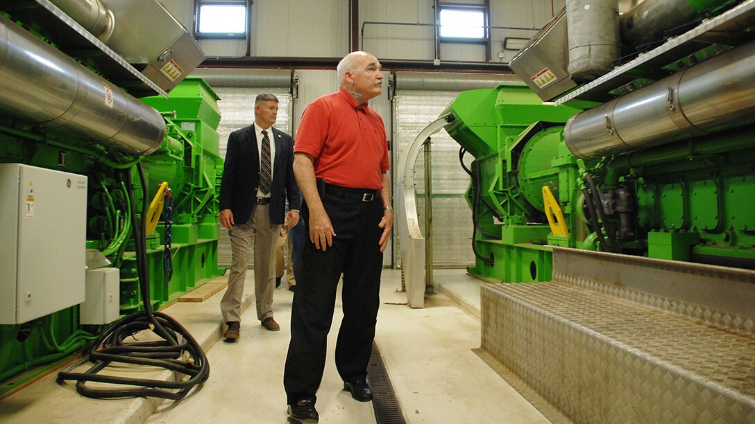 Assistant Secretary of the Navy, the Honorable Dennis V. McGinn (right), Energy, Installations and Environment, tours the landfill gas-to-energy project with Fred Broome, director, Installation and Environment Division, Marine Corps Logistics Base Albany, Georgia, May 19. The landfill gas-to-energy project is the first-of-its-kind within the Department of the Navy. It uses a 1.9 megawatt combined heat and power generator to recover methane gas from a neighboring landfill and converts it into energy and steam to help power Marine Depot Maintenance Command. A second generator is currently being installed, which will bring the plant’s total capacity up to 4.0 megawatts. 