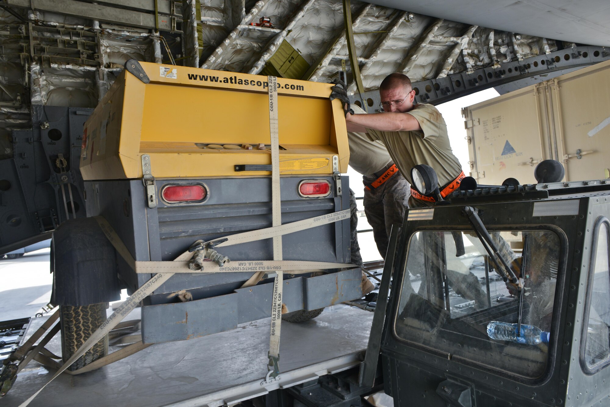 Airmen from the 8th Expeditionary Air Mobility Squadron load generators onto a C-17 Globemaster aircraft prior to take off May 13, 2015 at Al Udeid Air Base, Qatar. Airmen from separate squadrons deployed to Al Udeid helped support a mission for forward deployed members of RED HORSE Civil Engineering to repair a runway in Southwest Asia in support of Operation Inherent Resolve. (U.S. Air Force photo/Staff Sgt. Alexandre Montes)