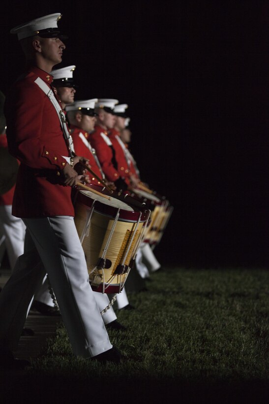 Members of the U.S. Marine Corps Drum and Bugle Corps, perform during the evening parade at Marine Barracks Washington, Washington, D.C., May 15, 2015. The Evening Parade summer tradition began in 1934 and features the Silent Drill Platoon, the U.S. Marine Band, the U.S. Marine Drum and Bugle Corps and two marching companies. More than 3,500 guests attend the parade every week. (U.S. Marine Corps photo by Lance Cpl. Alex A. Quiles/ Released)