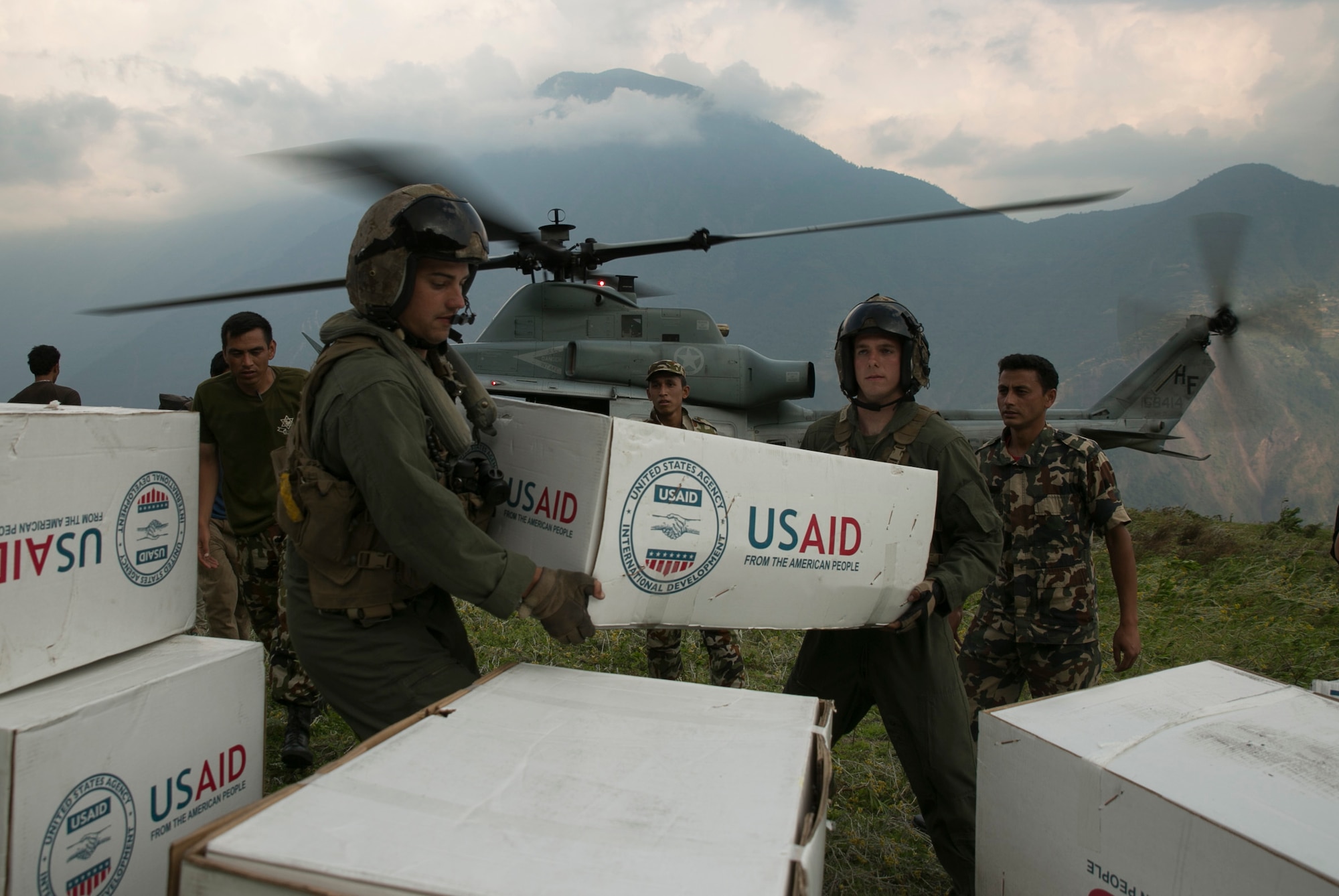 U.S. Marines and Nepalese soldiers unload tarps off of a UH-1Y Huey at Orang, Nepal, during Operation Sahayogi Haat, May 19, 2015. Joint Task Force 505 is drawing down its earthquake relief operations as the Nepalese government and international aid agencies have postured for long-term recovery and reconstruction efforts. Nepal announced its transition from relief operations to the recovery phase of disaster response May 19. (U.S. Marine Corps photo/Cpl. Isaac Ibarra) 