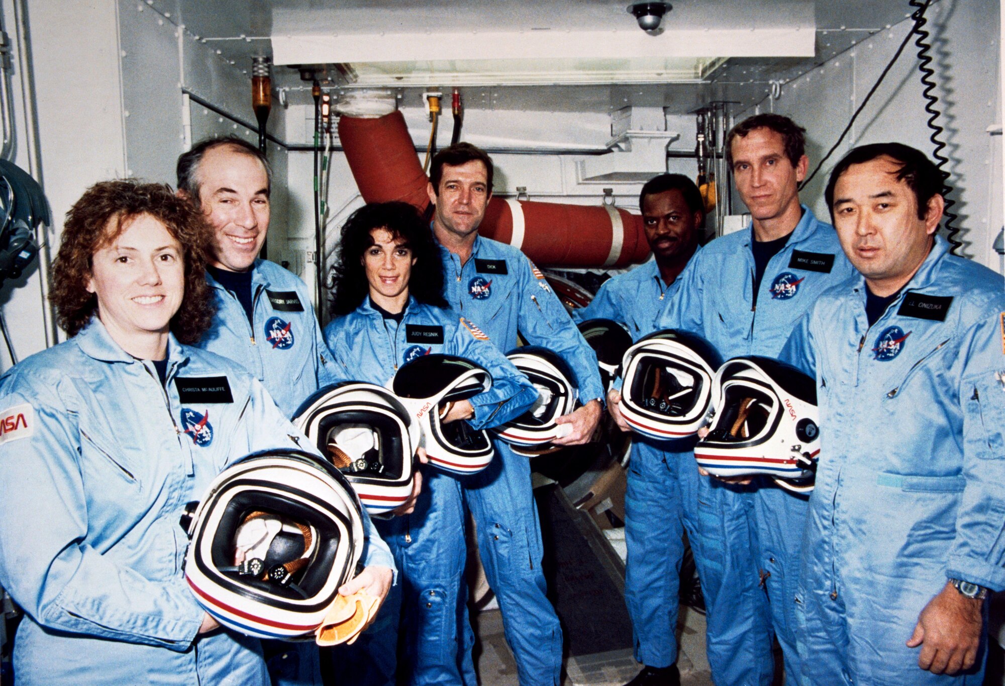 STS-51L crew members pose during a break in countdown training in the White Room at Launch Pad 39B in November of 1985. From the left are Christa McAuliffe, Gregory Jarvis, Judith Resnik, Francis "Dick" Scobee, Ronald McNair, Mike Smith and Ellison Onizuka. (Courtesy photo/NASA)