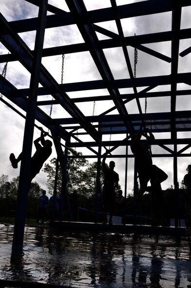 Savage Race participants shimmy across bars over a pool of water during the Georgia Spring 2015 Savage Race in Dallas, Ga., April 18, 2015. The Savage Race is an Air Force Reserve sponsored obstacle course that challenges participants in more than 20 different trials over the course of five miles. (U.S. Air Force photo/Senior Airman Daniel Phelps)