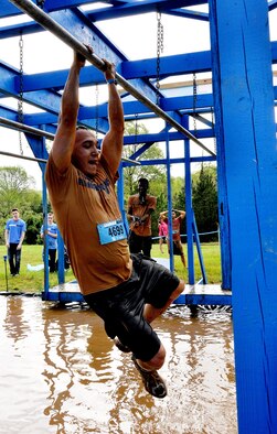 Tech. Sgt. Randy Estrella, 94th Logistics Readiness Squadron vehicle maintainer, shimmies across bars over a pool of water during the Georgia Spring 2015 Savage Race in Dallas, Ga., April 18, 2015. The Savage Race is an Air Force Reserve sponsored obstacle course that challenges participants in more than 20 different trials over the course of five miles. (U.S. Air Force photo/Senior Airman Daniel Phelps)