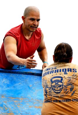 Staff Sgt. Luis Pluguez, 94th Aeromedical Staging Squadron, assists 1st Lt. Banner Zimmerman, 94th ASTS nurse, in climbing a wall during the Georgia Spring 2015 Savage Race in Dallas, Ga., April 18, 2015. The Savage Race is an Air Force Reserve sponsored obstacle course that challenges participants in more than 20 different trials over the course of five miles. (U.S. Air Force photo/Senior Airman Daniel Phelps)