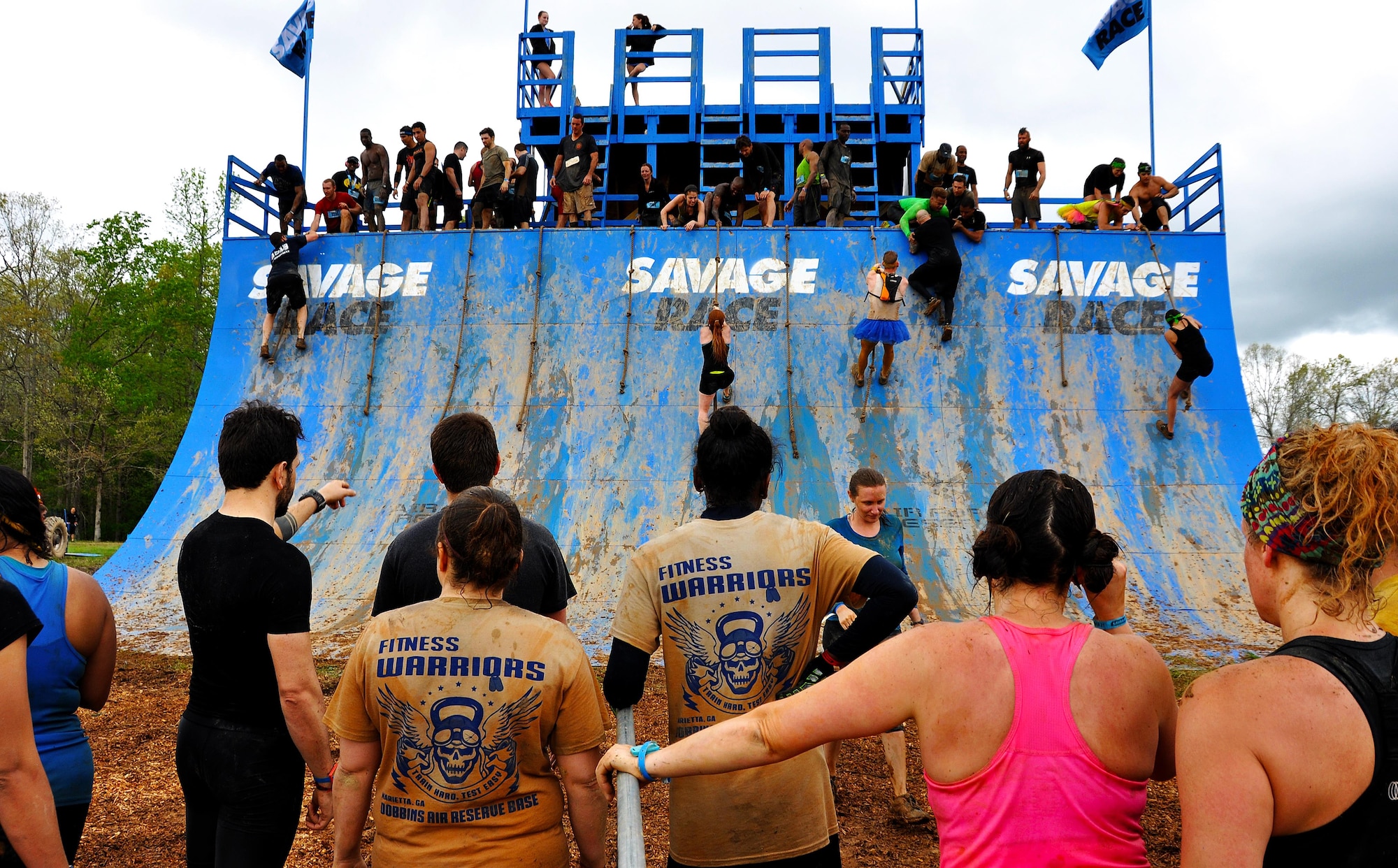 Savage Race participants wait in line to climb the Colossus during the Georgia Spring 2015 Savage Race in Dallas, Ga., April 18, 2015. The Colossus was a giant 43-foot wall and one of the hardest obstacles in the course. Adding to the difficulty of it being one of the final obstacles, runners had to sprint up the barrier after they’d already sledged through more than four miles in the mud, before grabbing a rope. They would then pull themselves up to the top of the fortification. The Savage Race is an Air Force Reserve sponsored obstacle course that challenges participants in more than 20 different trials over the course of five miles. (U.S. Air Force photo/Senior Airman Daniel Phelps)