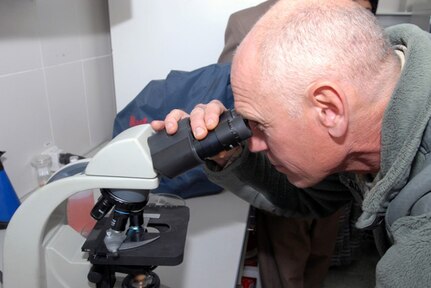 Army Maj. Loren Adams, a New Liberty, Iowa, resident and a veterinarian with the Iowa National Guard Agribusiness Development Team, examines an anthrax slide through a microscope in the Central Veterinary Research and Diagnostics Lab in Kabul City here during a tour Dec. 28. The tour gave a group of Army vets a better understanding of the lab’s capabilities which they will pass on to the Afghan veterinarians they work with, in their respective provinces.