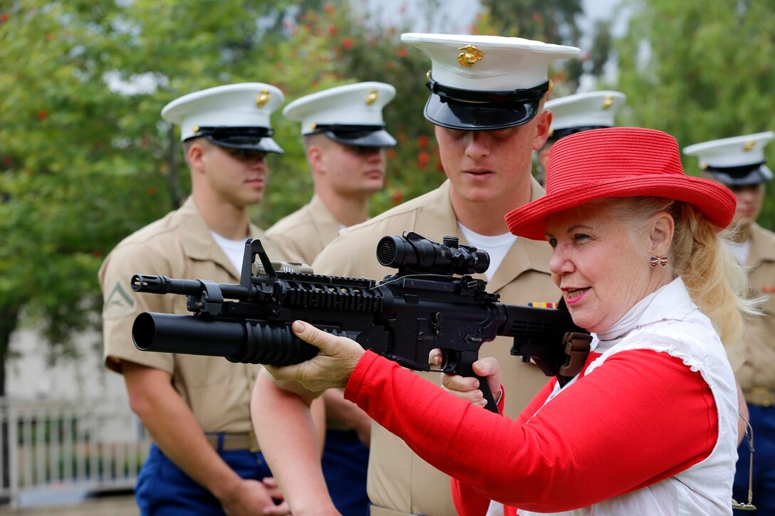 A woman examines an M4 Carbine with an M203 grenade launcher attachment during a display of capabilities by Marines of the 11th Marine Expeditionary Unit at the city of Yorba Linda during an adoption ceremony May 16. The 11th MEU is a flexible, adaptable and persistent force capable of rapidly responding to crises and contingencies. (U.S. Marine Corps photo by Gunnery Sgt. Rome M. Lazarus/Released)