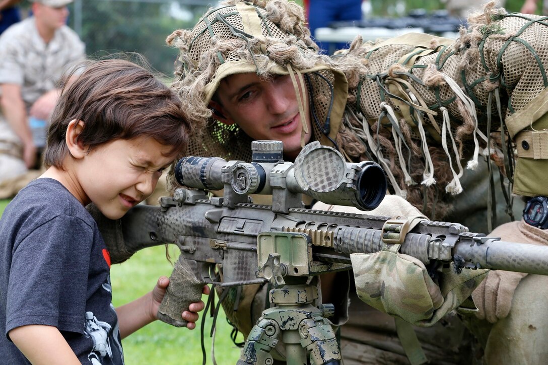 A child looks down the sight of an M110 semi-automatic sniper system (SASS) at a weapons showcase held by Marines of the 11th Marine Expeditionary Unit during a display of capabilities to the city of Yorba Linda for an adoption ceremony, May 16. The 11th MEU is a flexible, adaptable and persistent force capable of rapidly responding to crises and contingencies. (U.S. Marine Corps photo by Gunnery Sgt. Rome M. Lazarus/Released)