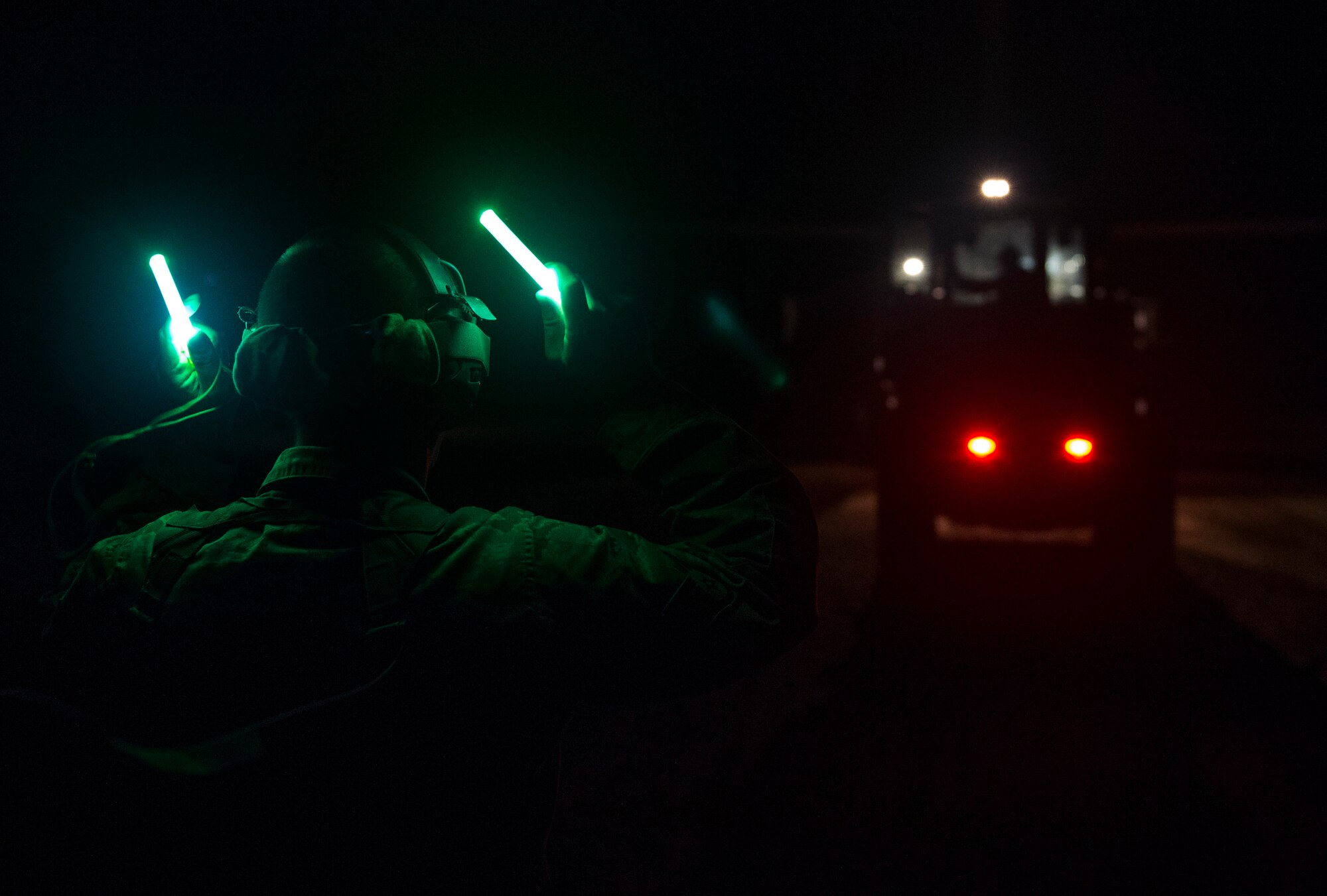 An Airman assigned to the 621st Contingency Response Wing spots an Airman operating a forklift in the dark while conducting night vision goggle training during the Joint Readiness Training Center exercise 15-07, May 16, 2015, at Fort Polk, La. (U.S. Air Force photo/Staff Sgt. Gustavo Gonzalez/RELEASED)