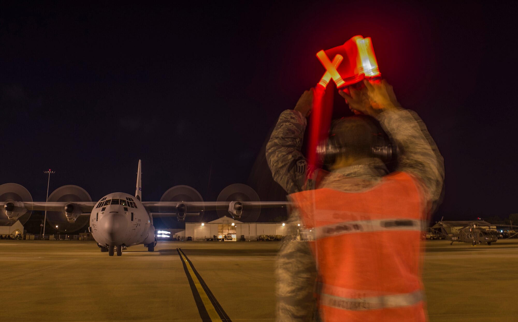 An Airman assigned to the 621st Contingency Response Wing marshals a U.S. Air Force C-130 Hercules during the Joint Readiness Training Center exercise 15-07, May 15, 2015, at the Alexandria International Airport, La. The training will help increase efficiency and expedite the process of loading cargo onto an aircraft. (U.S. Air Force photo/Staff Sgt. Gustavo Gonzalez/RELEASED)