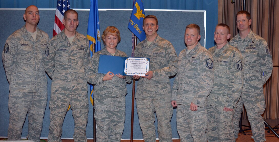 The Peterson Diamond Council gathers around SrA Holton as they present his Diamond Sharp Award.