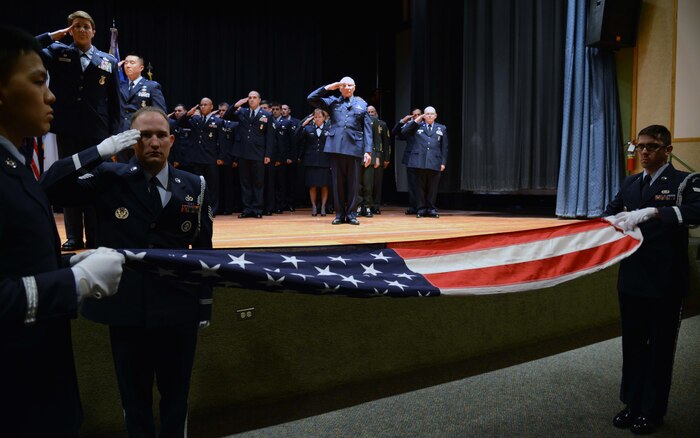 Retirees salute as the U.S. flag is folded during a retreat ceremony May 15, 2015, at Malmstrom Air Force Base, Mont. The retreat ceremony kicked off retiree appreciation weekend events. (U.S. Air Force photo/ Airman 1st Class Dillon Johnston)