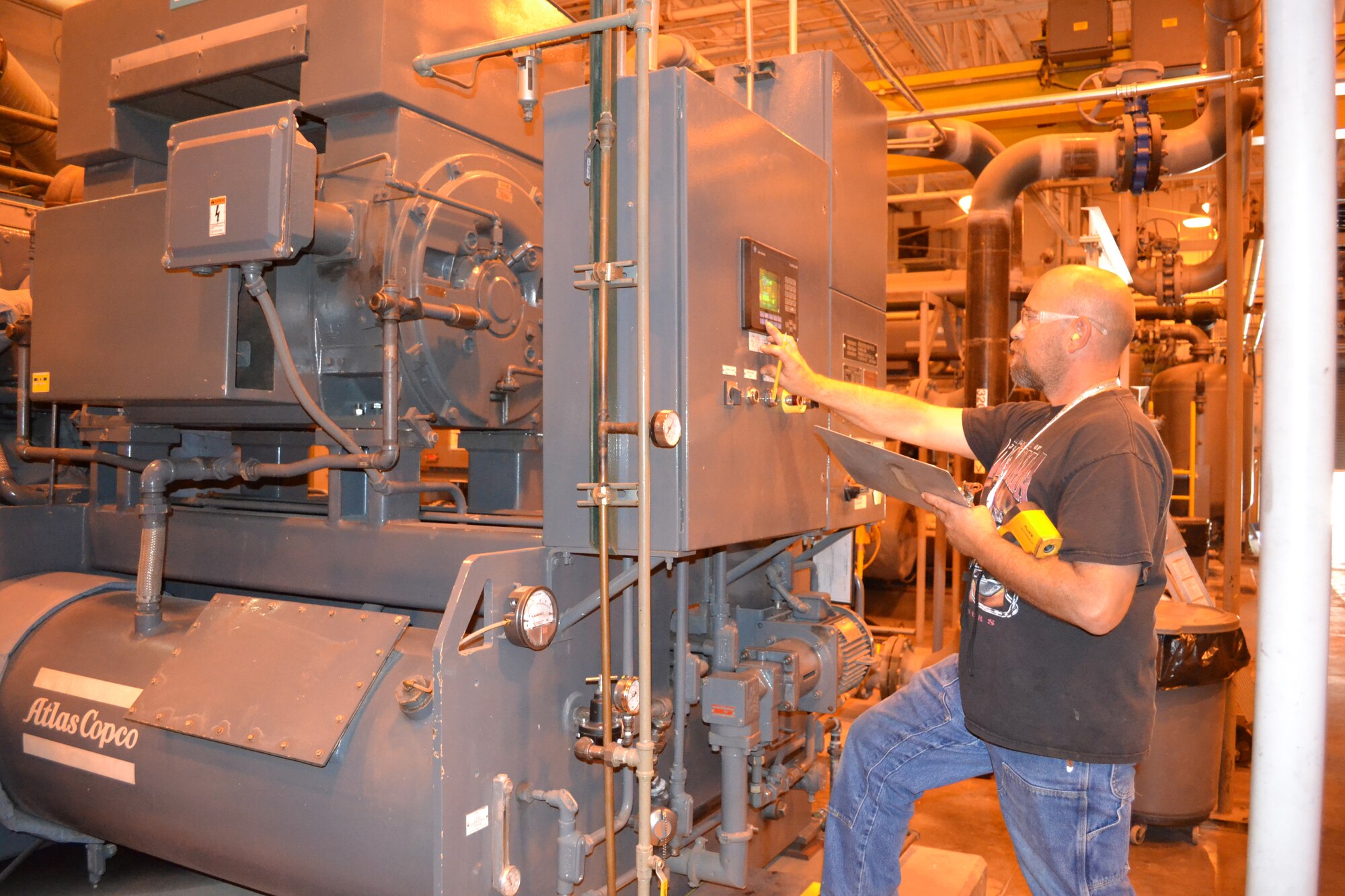 Patrick Duff, a production equipment mechanic with the 76th Maintenance Group, takes meter readings of the oil pressure and temperature, cooling water temperature and the output temperature on one of two 1,750 horsepower compressors.  Each compressor is capable of producing 4,500 cubic feet of air at 300 psi.  The shop also has a 3,000 horsepower compressor that produces 9,000 cubic feet of air at 300 psi. Through improved communication with production and closely monitoring air compressors, electric consumption is down 29% from three years ago.  Cost avoidance for the three years is over $800,000. (Air Force photo by Ron Mullan/Released)