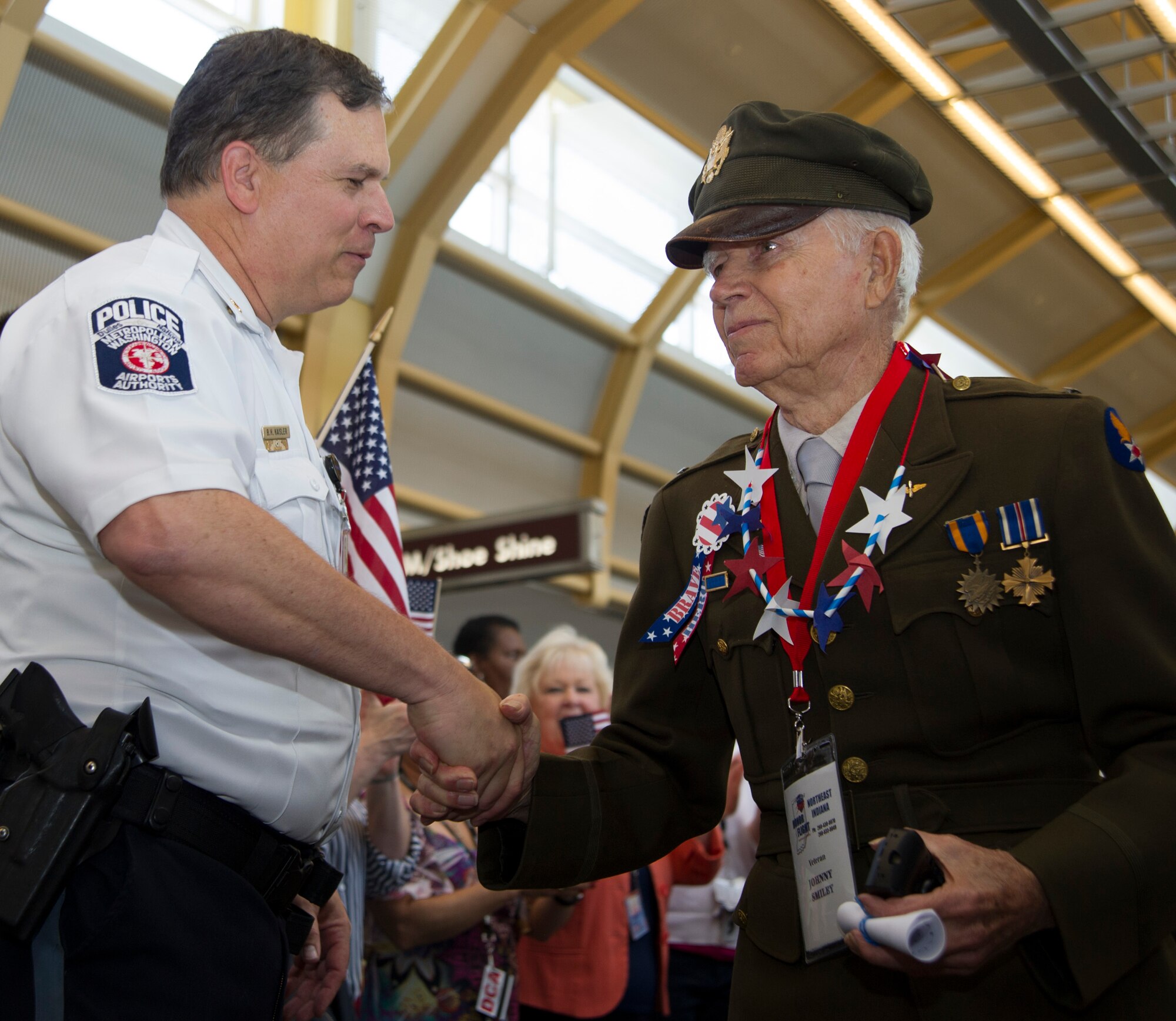 Maj. Brian Kaisler, Metropolitan Washington Airports Authority Police Department, greets Johnny Smiley, Army veteran, upon arrival at Ronald Reagan Washington National Airport in Arlington, Va., May 20, 2015. Smiley is in D.C. to visit the WWII Memorial with the Northeast Indiana Honor Flight. (U.S. Air Force photo/Airman 1st Class Ryan J. Sonnier)