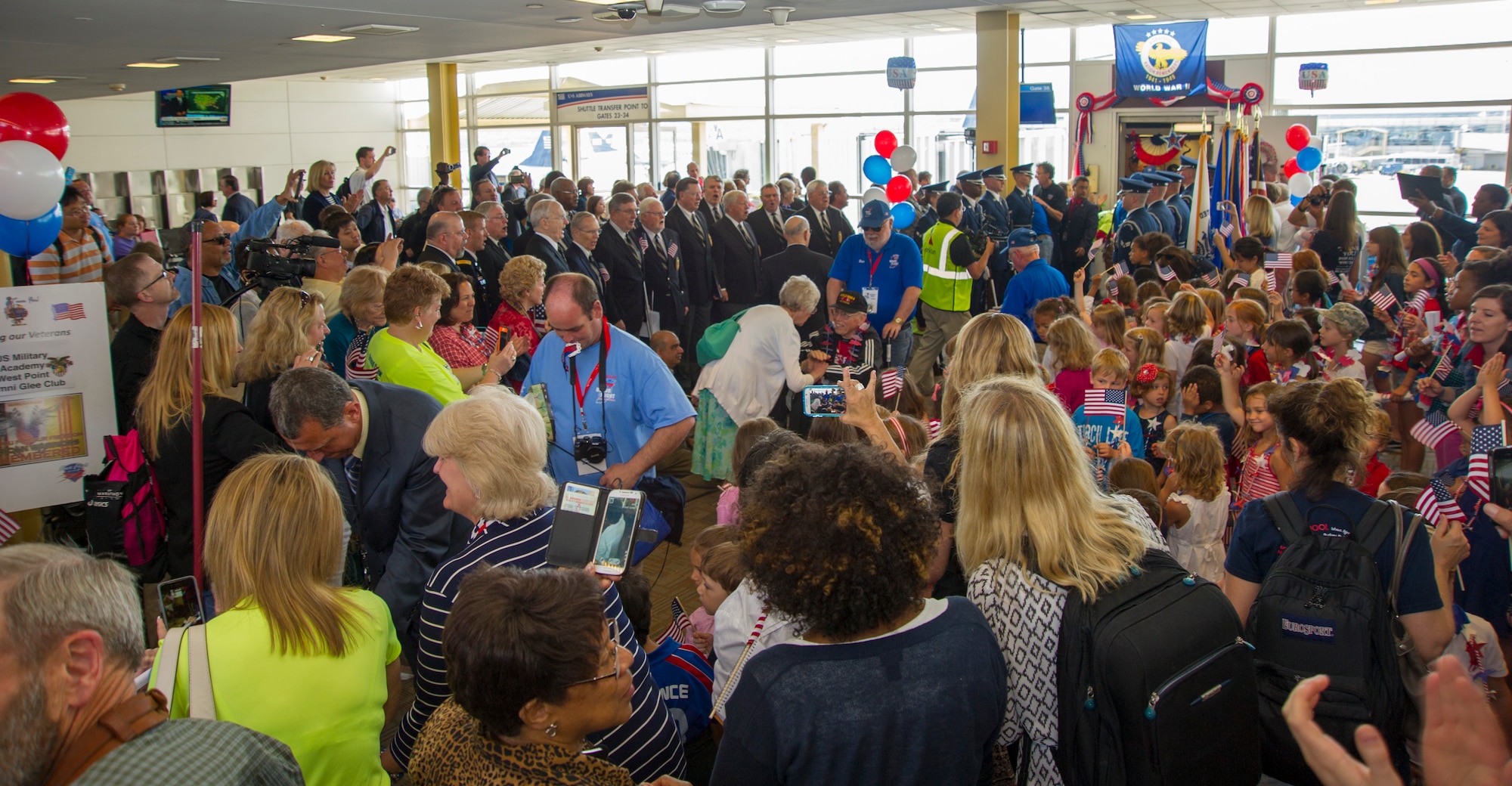 The U.S. Air Force Honor Guard and other patrons celebrate the arrival of the Northeast Indiana Honor Flight at Ronald Reagan Washington National Airport in Arlington, Va., May 20, 2015. The U.S. Air Force HG presented an eight-man cordon to welcome the Honor Flight. (U.S. Air Force photo/Airman 1st Class Ryan J. Sonnier)