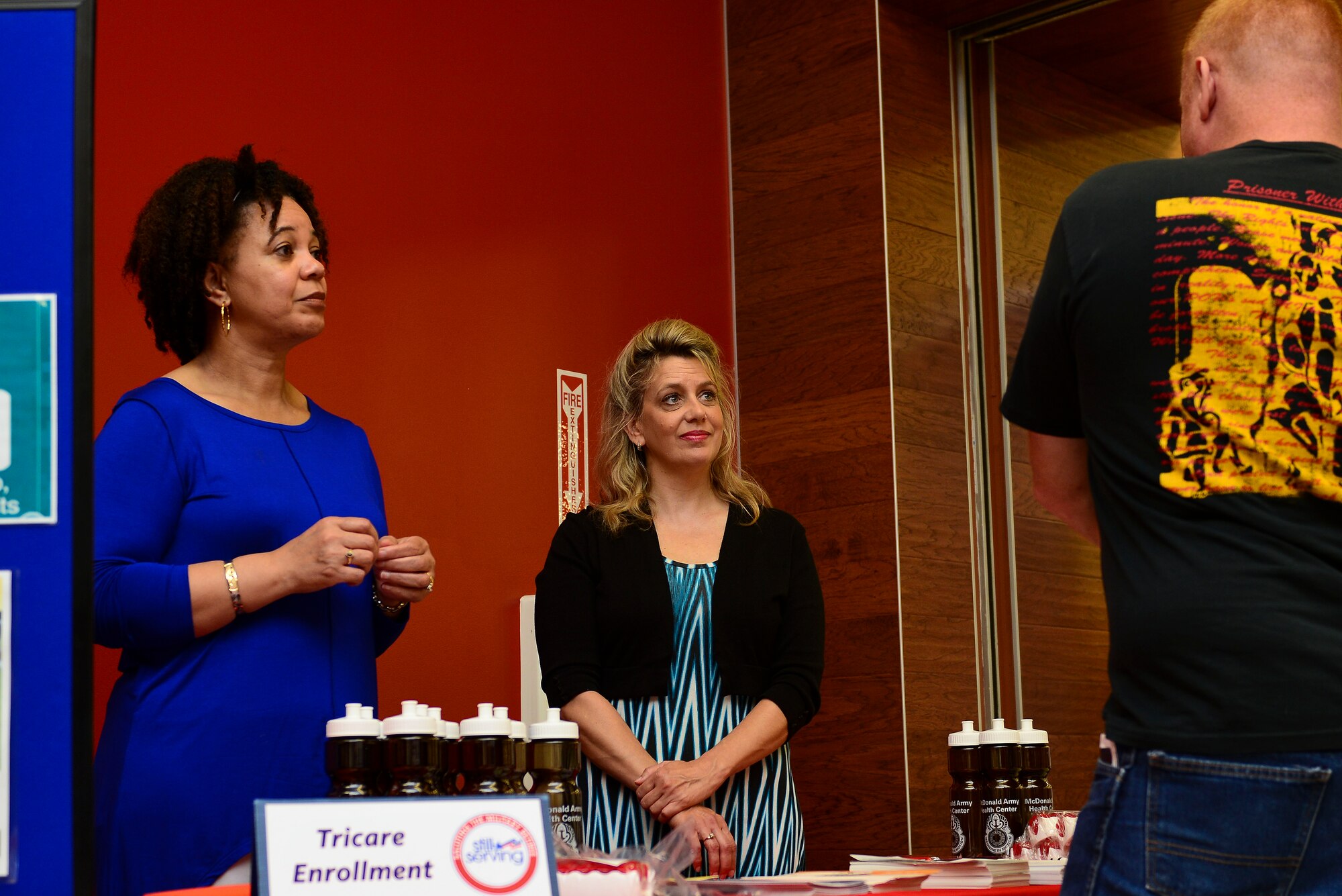Joanne Pope, McDonald Army Health Center, contact representative, left, and Jennifer Langdon, MCAHC clinical work flow analyst speak with Retired U.S. Army Staff Sgt. Brett Rhen and others during the Joint Base Langley-Eustis Retiree Appreciation Day at Fort Eustis, Va., May 16, 2015. The health center had multiple booths explaining health care and what the center can do for the retirees.  (U.S. Air Force photo by Senior Airman Kimberly Nagle/Released)  