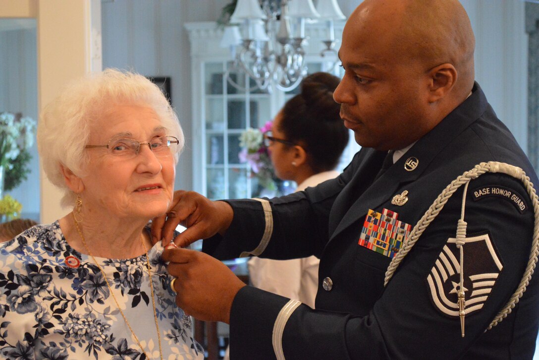 U.S. Air Force Master Sgt. Elroy Williams, 633rd Force Support Squadron Self-Assessment program manager, pins the wife of a veteran during an Armed Forces Day pinning ceremony at a hospice in Williamsburg, Va., May 16, 2015. The event was done in honor of veterans and families of veterans who have served in the military in support of our nation. (Courtesy Photo) 
