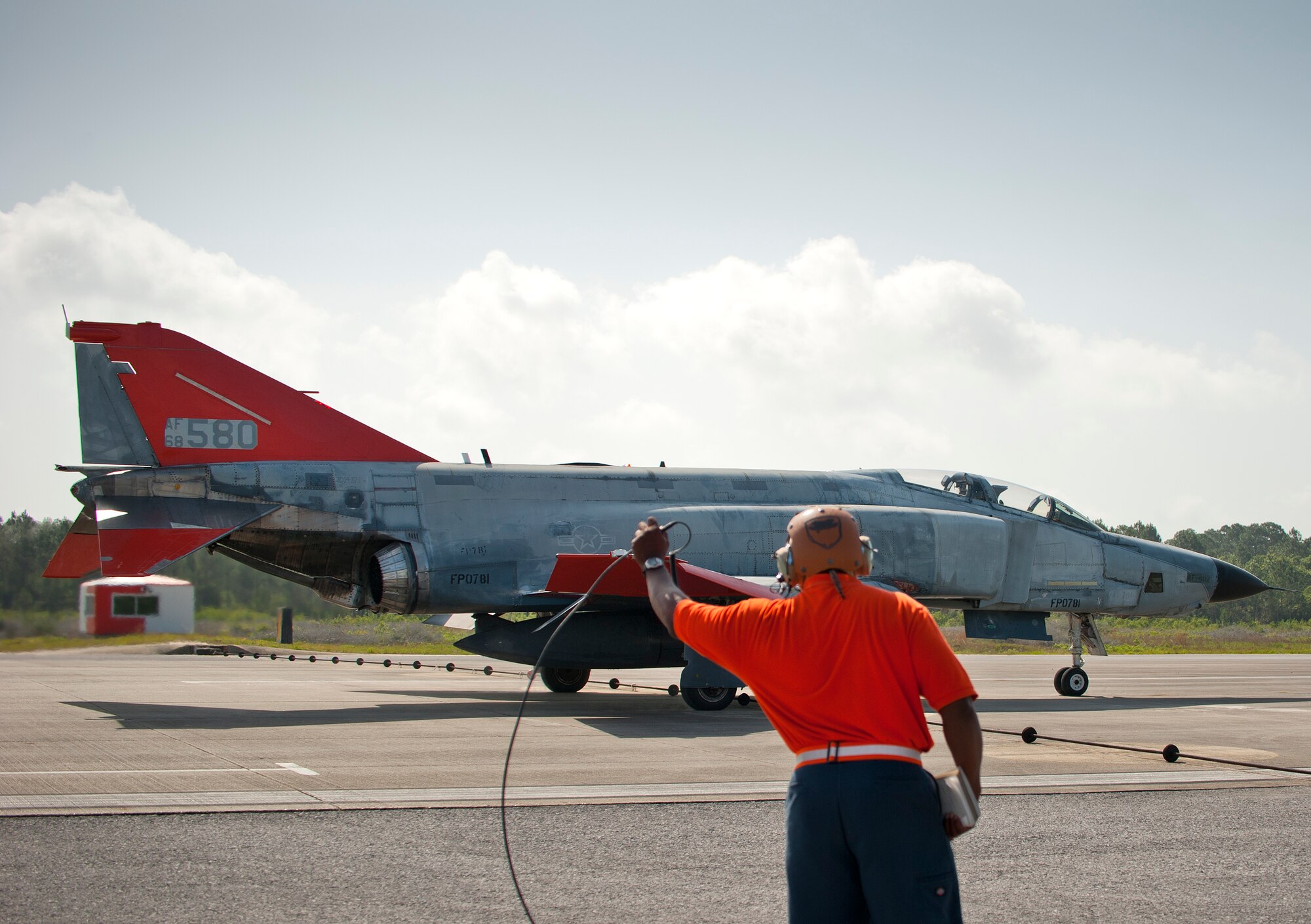 A PAE maintainer directs an unmanned QF-4 down the drone runway for takeoff May 12 at Tyndall Air Force Base, Fla. This QF-4 was used as a full-scale target and shot down by a pilot from the 177th Fighter Wing, a New Jersey Air National Guard unit, who were participating in Combat Archer. Combat Archer is the air-to-air component of the 53rd Wing’s weapons system evaluation program.  The 82nd Aerial Targets Squadron operates QF-4, QF-16 and BQM-167 targets to provide manned and unmanned aerial targets support for programs across the Department of Defense. The QF-4 mission for the 82nd ATRS at Tyndall came to an end in May, with the squadron transitioning to QF-16s for all future full-scale target operations. (U.S. Air Force photo/Sara Vidoni)