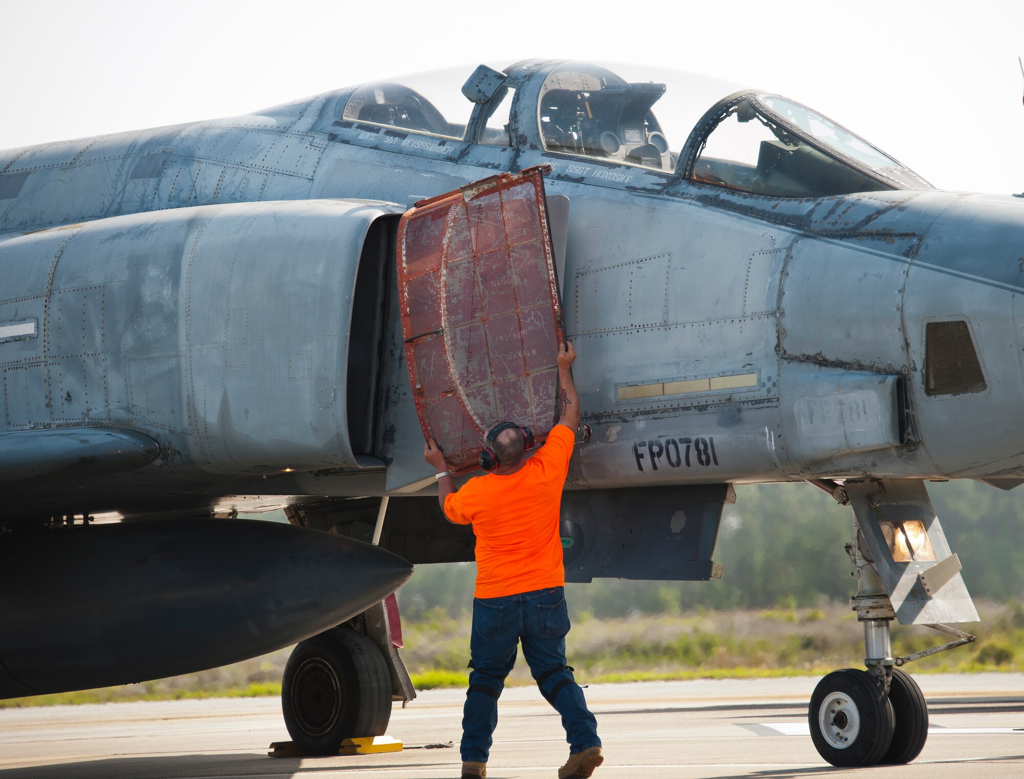 A PAE maintainer removes an engine inlet screen from a QF-4 prior to takeoff on the drone runway May 12 at Tyndall Air Force Base, Fla. This unmanned QF-4 was used as a full-scale target and shot down by a pilot from the 177th Fighter Wing, a New Jersey Air National Guard unit, who were participating in Combat Archer. Combat Archer is the air-to-air component of the 53rd Wing’s weapons system evaluation program.  The 82nd Aerial Targets Squadron operates QF-4, QF-16 and BQM-167 targets to provide manned and unmanned aerial targets support for programs across the Department of Defense. The QF-4 mission for the 82nd ATRS at Tyndall came to an end in May, with the squadron transitioning to QF-16s for all future full-scale target operations. (U.S. Air Force photo/Sara Vidoni)