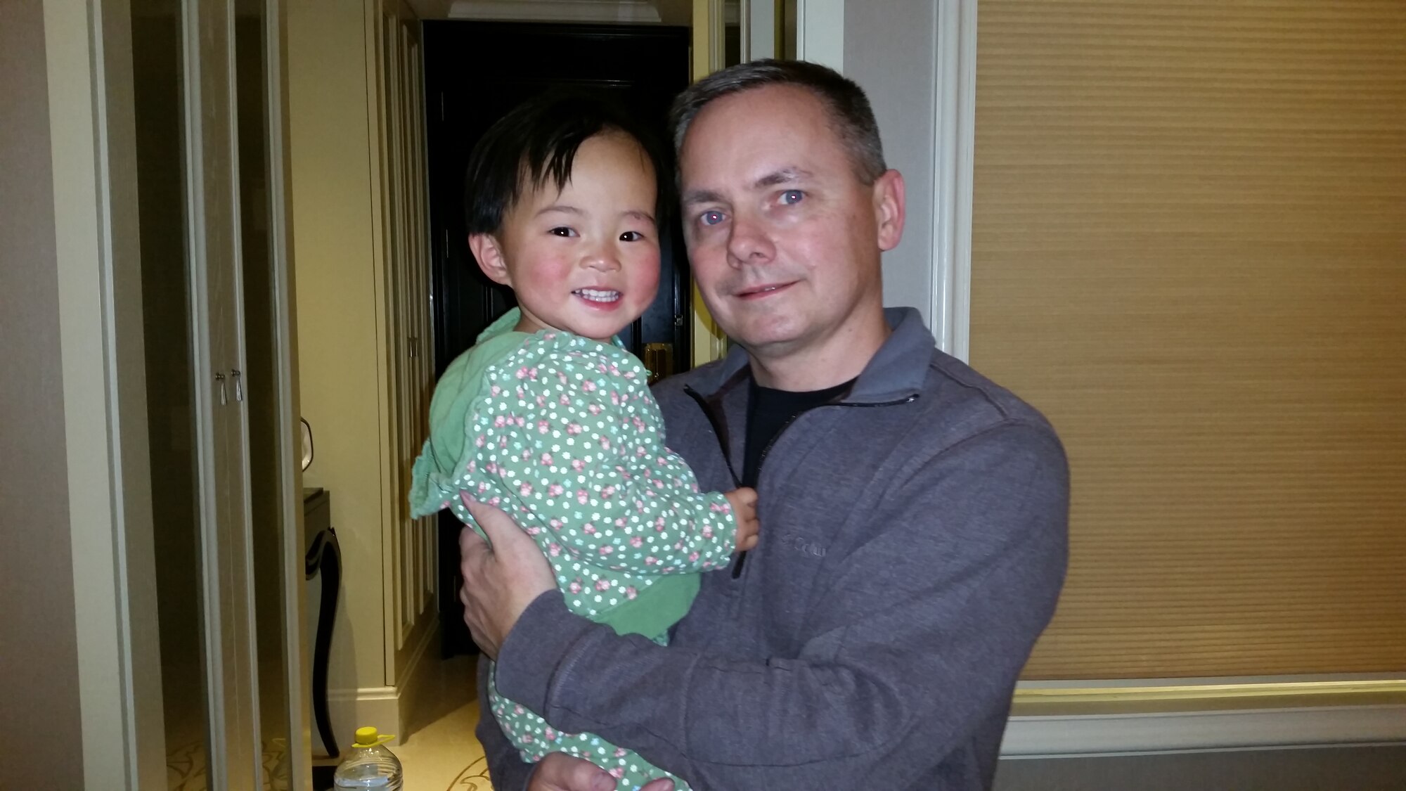 U.S. Air Force Col. Todd Krueger, a senior materiel leader at Hanscom AFB, Mass., holds his newly adopted daughter Susan in a hotel in  Zhengzhou, Henan Province, China, Dec. 15, 2014. This was the first day, commonly known as "Gotchya Day," where the Kruegers became the official parents of their Chinese Waiting Child. (courtesy photo)