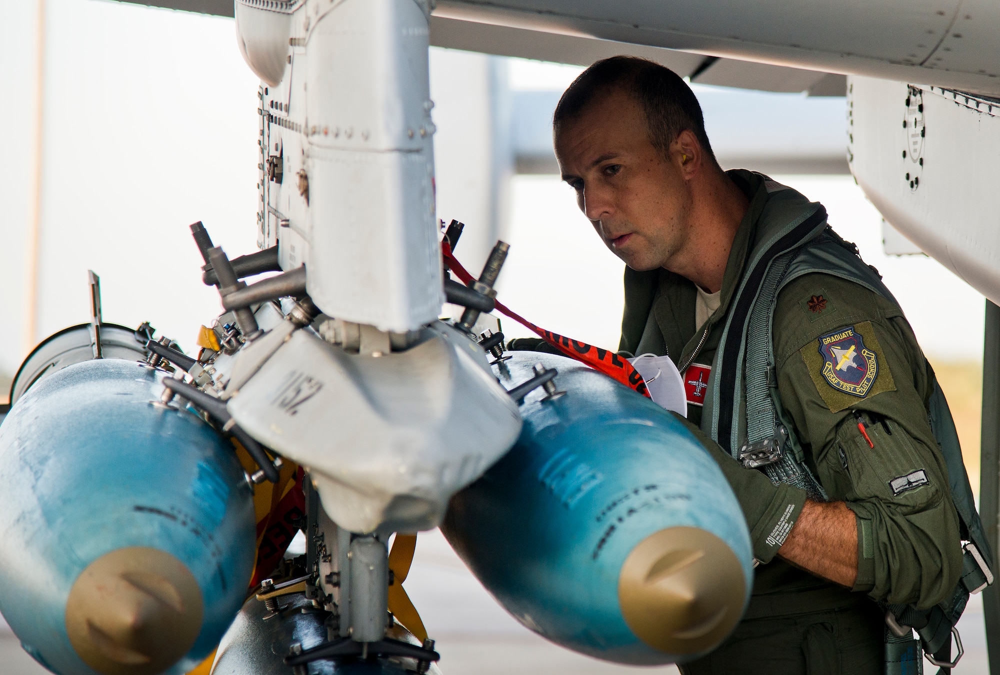 Maj. Joe McGill, a flyer for the 40th Flight Test Squadron, performs checks on the bombs attached to the wing of an A-10 Thunderbolt II prior to a morning takeoff from Eglin Air Force Base, Fla., May 19.  The aircraft was loaded with approximately nine MK-82s, seven missiles and a full 30mm round load for the GAU-8. The sortie was to test the weapons worked properly with new aircraft software upgrades.  (U.S. Air Force photo/Samuel King Jr.)