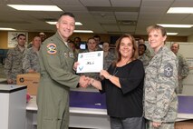 Christine Ingle, center, 47th Communications Squadron Cyber Operations flight chief, poses with Col. Brian Hastings, 47th Flying Training Wing commander, and Chief Master Sgt. Teresa Clapper, 47th FTW command chief, after accepting the XLer of the Week award here May 13, 2015. The XLer is a weekly award chosen by wing leadership and is presented to those who consistently make outstanding contributions to their unit and Laughlin. (U.S. Air Force photo by Airman Brandon May)(Released)