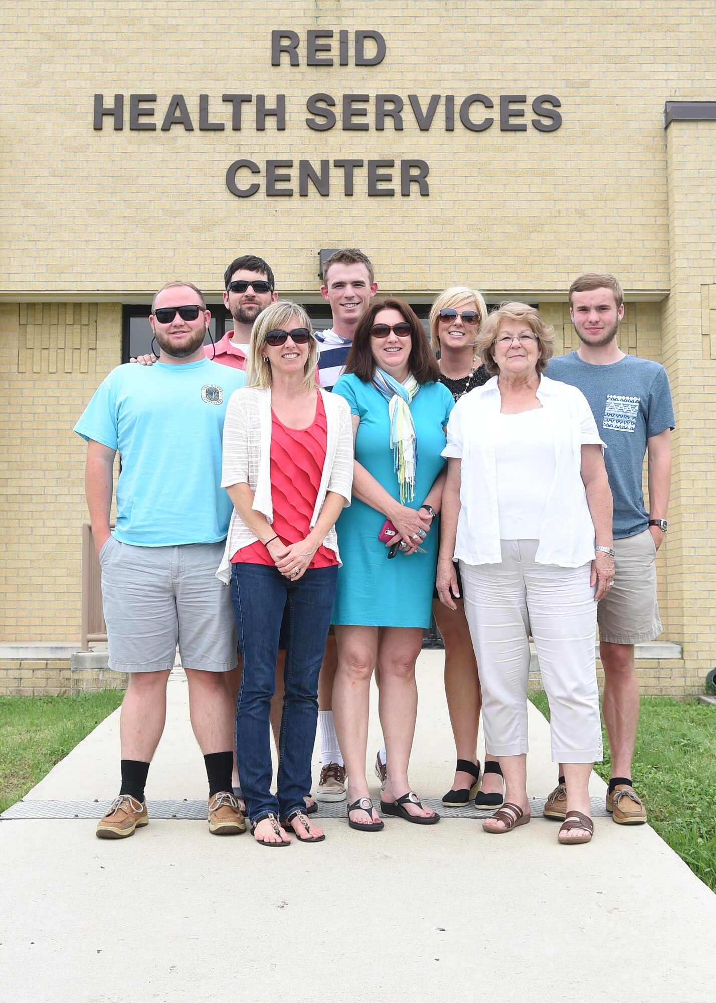 Family of the late Senior Master Sgt. David B. Reid pose for a photo in front of the Reid Health Services Center May 14, 2015 on Joint Base San Antonio-Lackland, Texas. The clinic was named in honor of Reid who was killed in a C-130 plane crash en route to Honduras in 1985. (U.S. Air Force photo/Staff Sgt. Chelsea Browning)