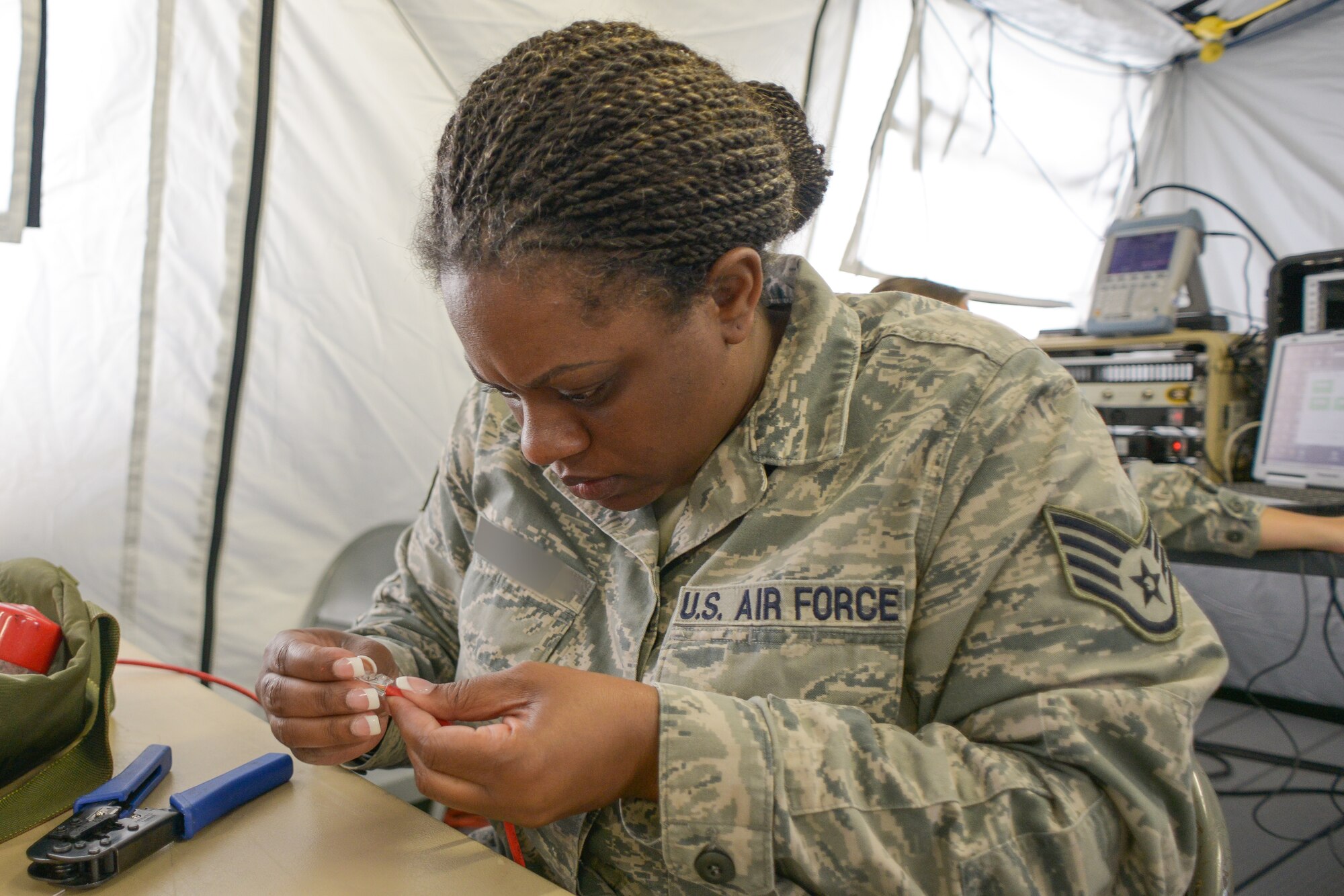 A client systems journeyman with the 283rd Combat Communications Squadron (CCS) from Dobbins Air Reserve Base, Georgia Air National Guard, terminates the end of a Cat-5 cable for a Theater Deployable Communications System during the Sentry Savannah 15-2 exercise at The Air Dominance Center, Savannah, Ga., May 8, 2015. Sentry Savannah is a National Guard Bureau sponsored training event with a focus on Joint Dissimilar Air Combat Training and 5th Generation Fighter Integration. It offers a chance for fighter pilots to participate in war simulations that depict what they would face in real-world scenarios. During the exercise the 283rd CBCS provided NIPR, SIPR, and voice services to the 117th Air Control Squadron Air Battle Element and extended service to their deployed radar site. Working together the two units provided vital data to help the fighter pilots complete their missions. (U.S. Air National Guard photo by the 116th Air Control Wing Public Affairs/Released) (Name of military member has been blurred and withheld for security purposes)