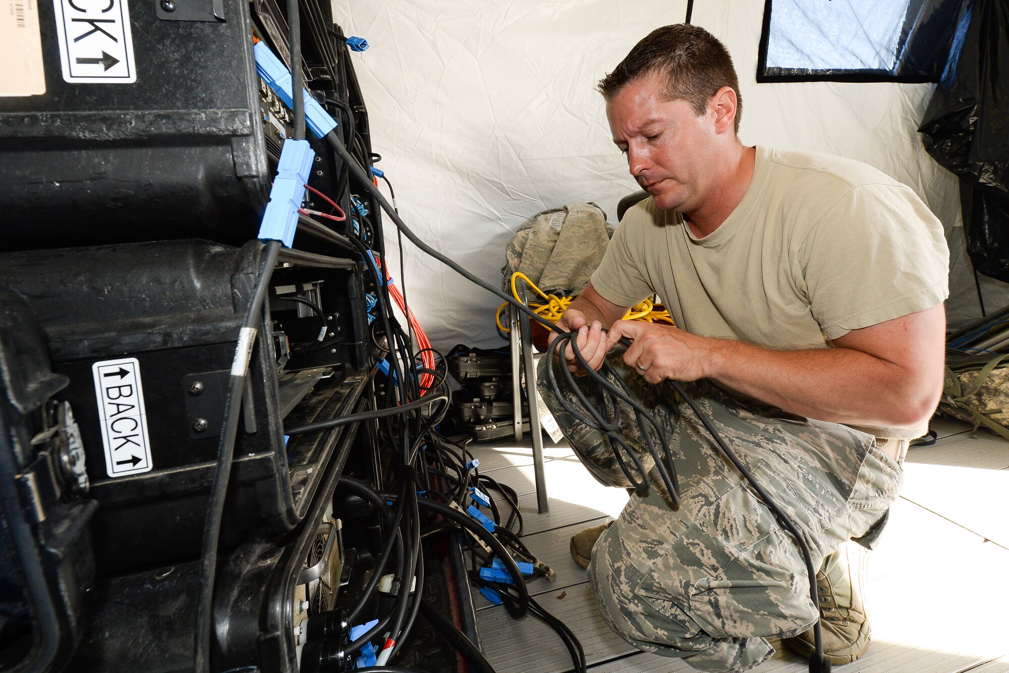 A cyber transport craftsman with the 283rd Combat Communications Squadron (CCS) from Dobbins Air Reserve Base, Georgia Air National Guard, organizes cables during set up of a Theater Deployable Communications System during the Sentry Savannah 15-2 exercise at The Air Dominance Center, Savannah, Ga., May 8, 2015. Sentry Savannah is a National Guard Bureau sponsored training event with a focus on Joint Dissimilar Air Combat Training and 5th Generation Fighter Integration. It offers a chance for fighter pilots to participate in war simulations that depict what they would face in real-world scenarios. During the exercise the 283rd CBCS provided NIPR, SIPR, and voice services to the 117th Air Control Squadron Air Battle Element and extended service to their deployed radar site. Working together the two units provided vital data to help the fighter pilots complete their missions. (U.S. Air National Guard photo by the 116th Air Control Wing Public Affairs/Released) (Name of military member withheld for security purposes)