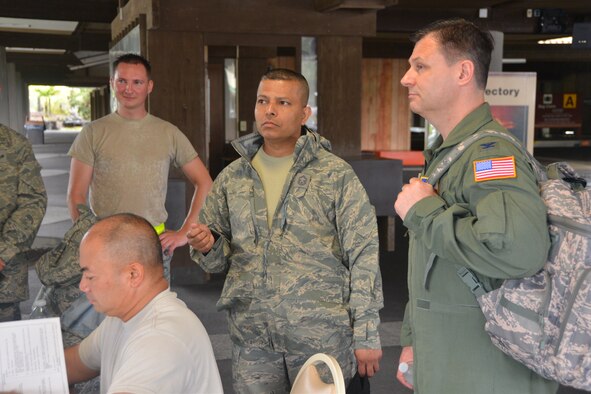 Senior Master Sgt. Vishal Rose, (center) superintendent/lead from the 74th Aerial Port Squadron briefs Col. Lee Merkle, commander, 433rd Operations Group at the Hilo Hawaii International Airport, May 16, 2015. Roses’ job as superintendent/lead was to provide in-transit visibility and to ensure a safe movement of all cargo and passengers for the “ALOHA STAMPEDE” exercise both in and out of JBSA-Lackland and Hilo International Airport. (U.S. Air Force photo/Minnie Jones)