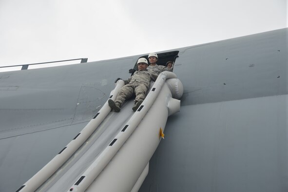 433rd Airlift Wing members practice egress non-ejection from a C-5A Galaxy aircraft May 17, 2015 at Hilo Hawaii International Airport in Hilo, Hawaii during for the wing’s first major training exercise dubbed “Aloha Stampede.” Other training included, self aid and buddy care, land and water survival training, air-refueling, cargo preparation, and increment monitoring of cargo for inspection during all phases of the exercise to include pre-deployment, deployment, and redeployment. (U.S. Air Force photo/Minnie Jones)