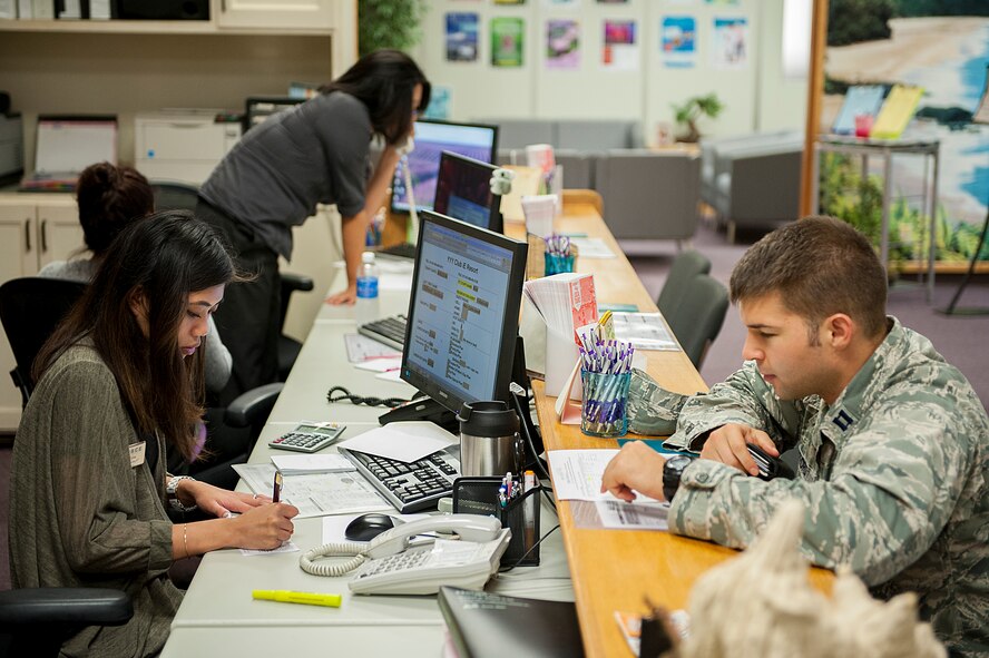 Kim Tato, 18th Force Support Squadron information, tickets, and travel desk clerk, helps a military member set up an on-island tour on Kadena Air Base, Japan, May 20, 2015. The 18th FSS has around 2,500 employees, more than 400 facilities and about 60 unique programs and businesses on the island making it the biggest force support squadron for any Air Force base in the world. (U.S. Air Force photo by Senior Airman Stephen G. Eigel)