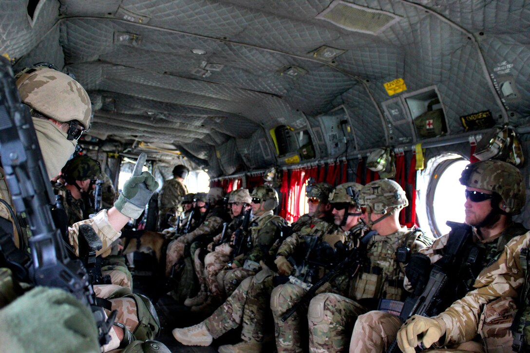 A Czech soldier signals other troops to prepare to dismount a CH-47 Chinook helicopter to conduct a security patrol led by Afghan soldiers in Parwan province, Afghanistan, May 8, 2015.