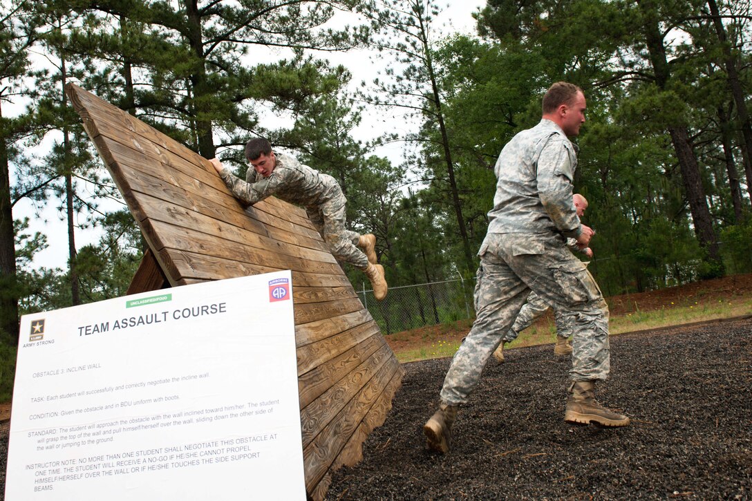 Paratroopers compete in the incline wall obstacle event, part of the team assault course competition during All-American Week on Fort Bragg, N.C. May 19, 2015.