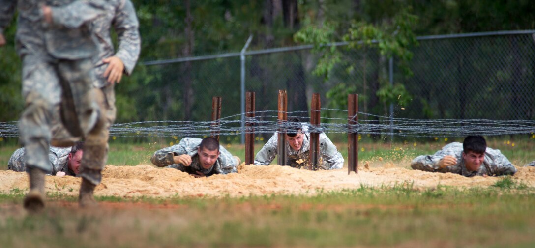Paratroopers crawl under the barbed wire obstacle part of the team assault course competition during All-American Week on Fort Bragg, N.C. May 19, 2015. 