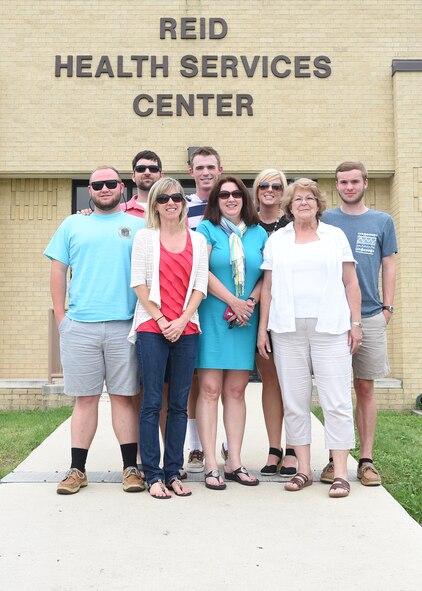 Family of the late Senior Master Sgt. David B. Reid pose for a photo in front of the Reid Health Services Center May 14, 2015 on Joint Base San Antonio-Lackland, Texas. The clinic was named in honor of Reid who was killed in a C-130 plane crash en route to Honduras in 1985. (U.S. Air Force photo by Staff Sgt. Chelsea Browning)