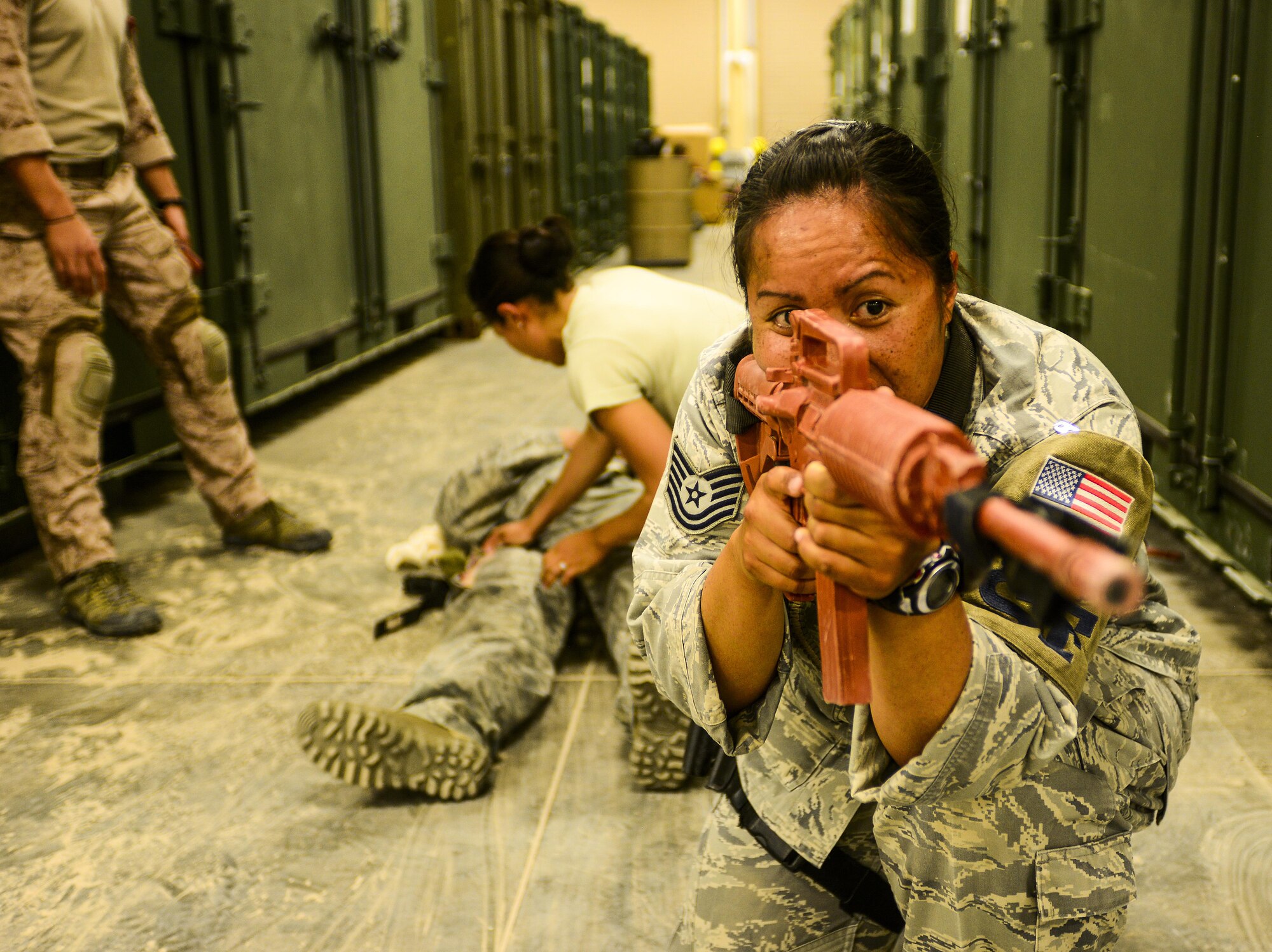 Tech. Sgt. Tashalynn Willing, 379th Expeditionary Security Forces Squadron non-commissioned officer in charge of operations, takes point while Airmen behind her perform care under fire procedures during a tactical combat casualty care scenario April 16, 2015, at a warehouse on Al Udeid Air Base, Qatar. The women of the 379th ESFS learned combatives, personal security detail procedures, treatment of combat trauma wounds, patient sustainment, and transportation.  (U.S. Air Force photo by Tech. Sgt. Caitlyn Thompson)