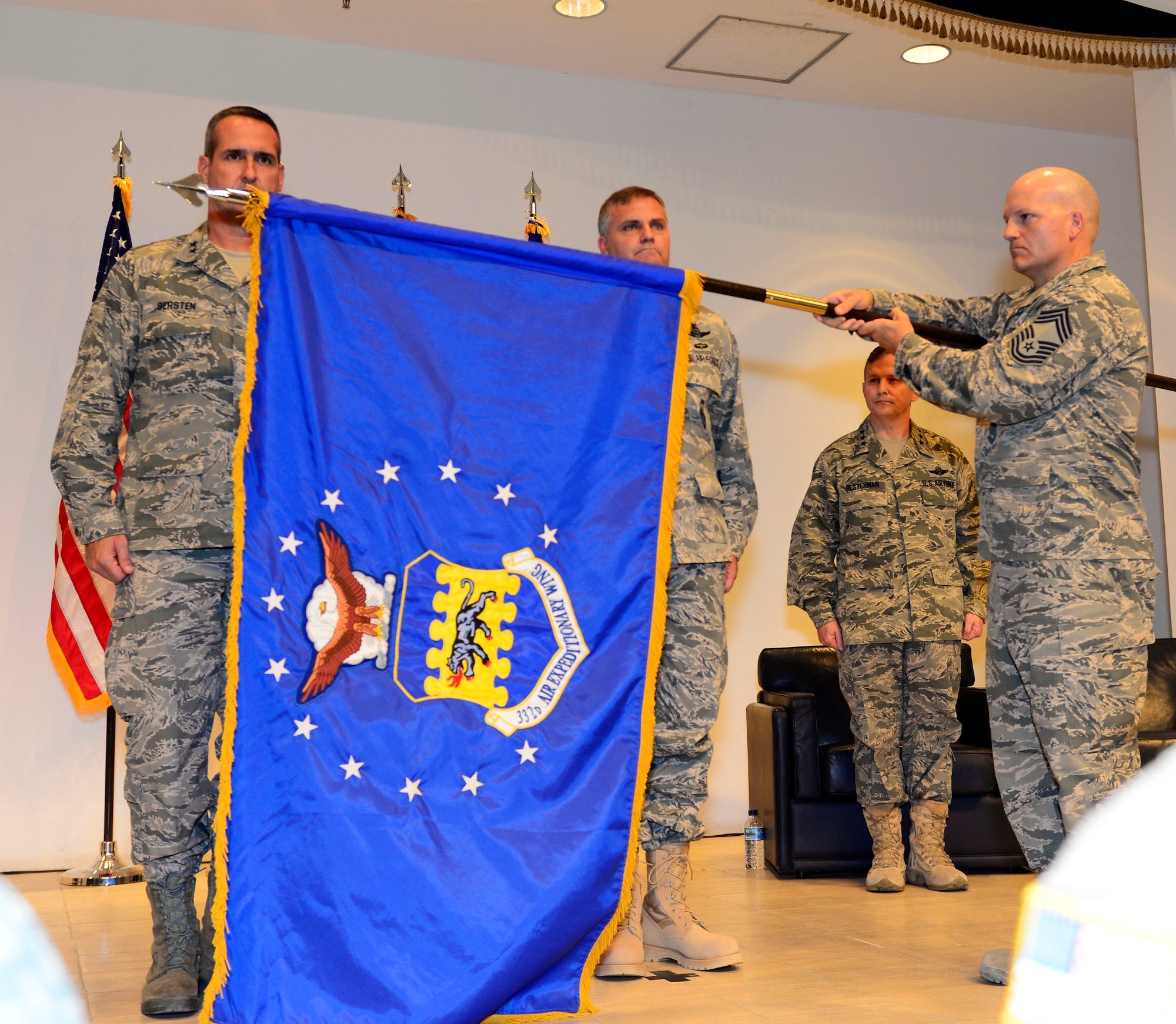 The 332nd Air Expeditionary Wing guidon was unfurled during an activation and assumption of command ceremony at an undisclosed location in Southwest Asia May 19, 2015. The 332nd AEW has a distinguished lineage, which includes the 332nd Air Expeditionary Group, the famed Tuskegee Airmen, also known as the Red Tails. (U.S. Air Force photo by Senior Airman Racheal E. Watson)