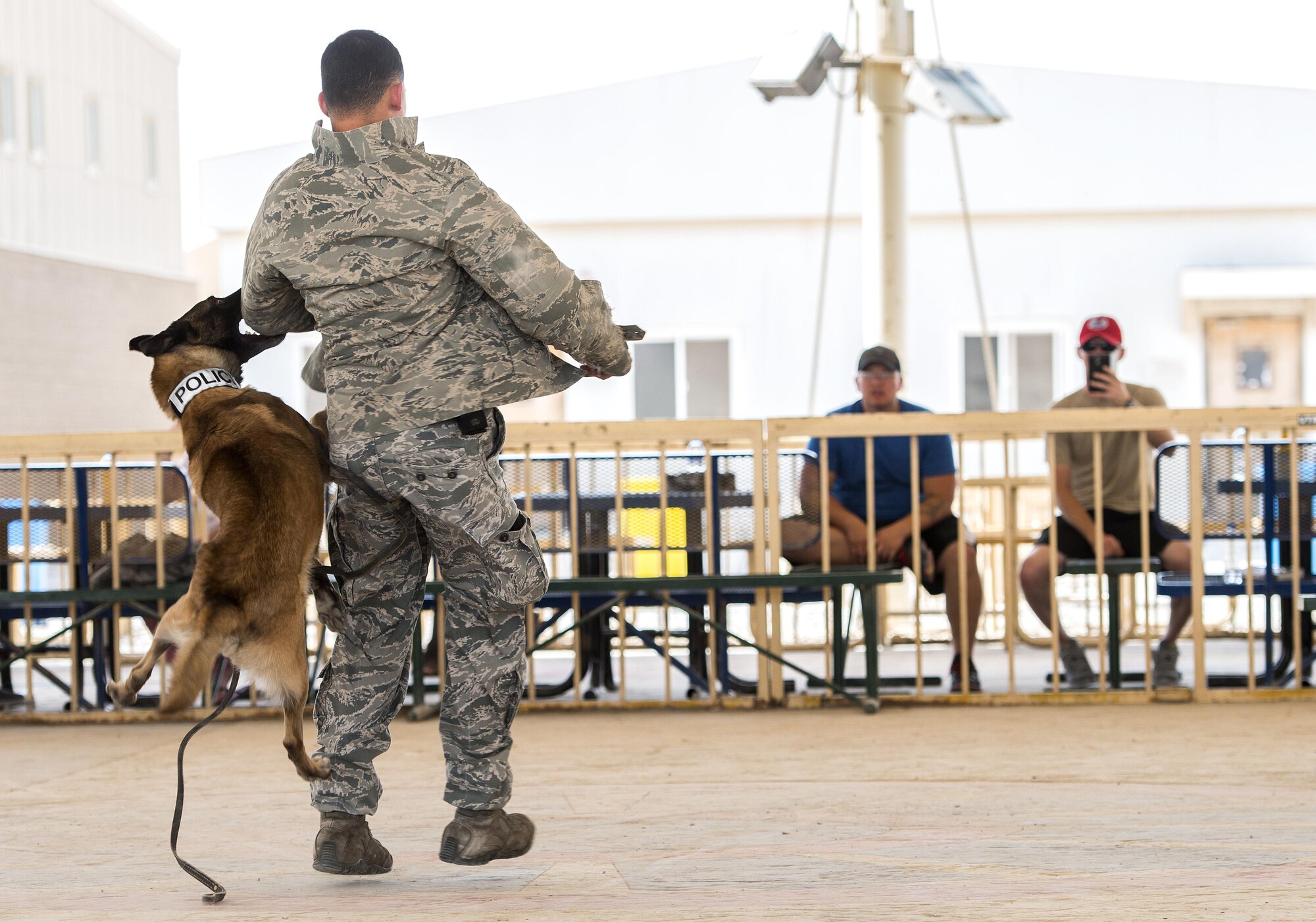 Tze, a military working dog, latches onto Air Force Staff Sgt. Jonathan Calo during a K-9 demonstration May 12, 2015, at Memorial Plaza on Al Udeid Air Base, Qatar. Calo, a military working dog handler, and Tze are assigned to the 379th Expeditionary Security Forces Squadron. The 379th ESFS held other various events during National Police Week consisting of an opening ceremony, a fallen officer memorial 5K run, and a "Defender Challenge". (U.S. Air Force photo by Tech. Sgt. Douglas)